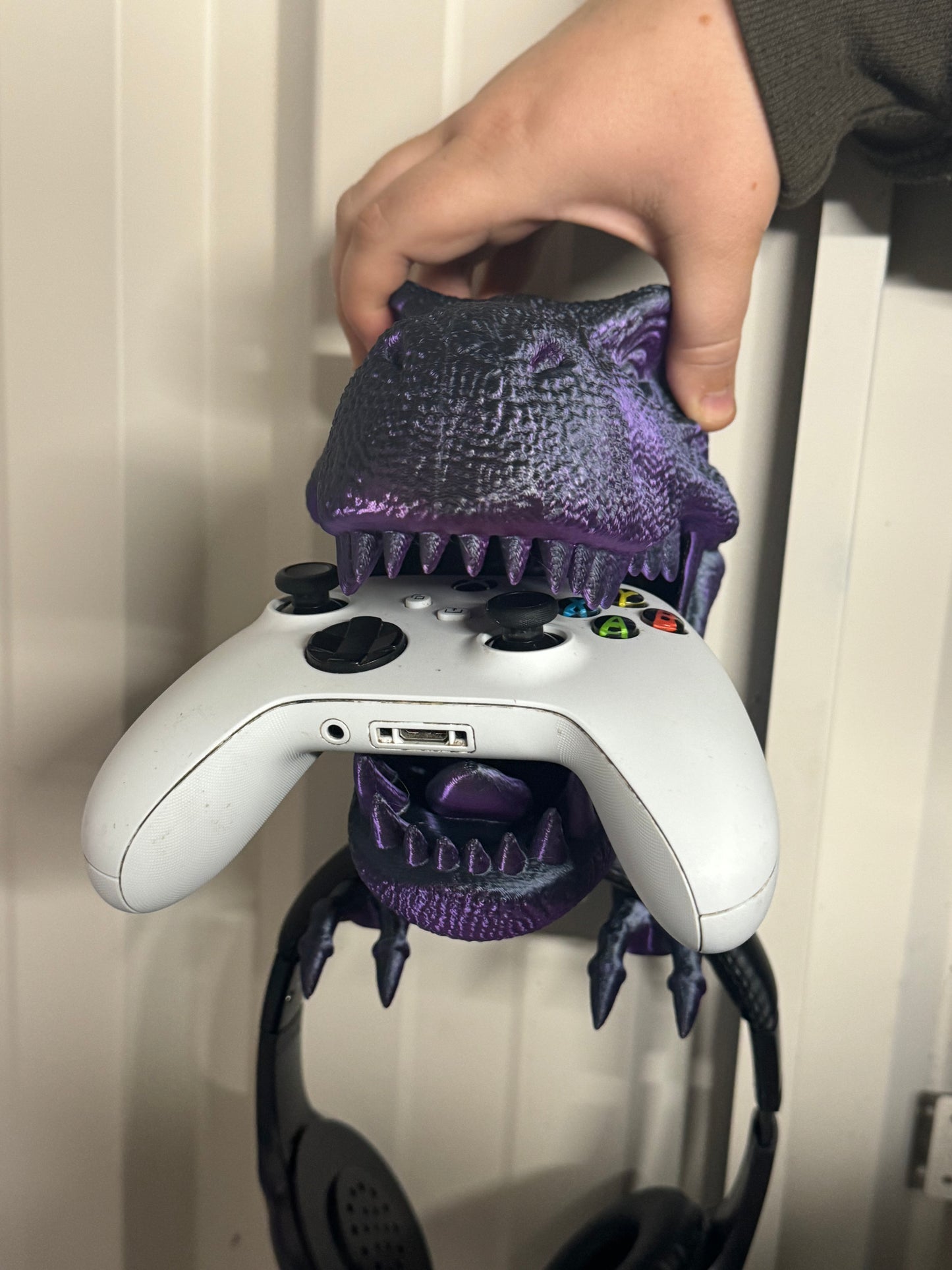 Wall mount dinosaur head holds head phones and Xbox remote/playstation remote